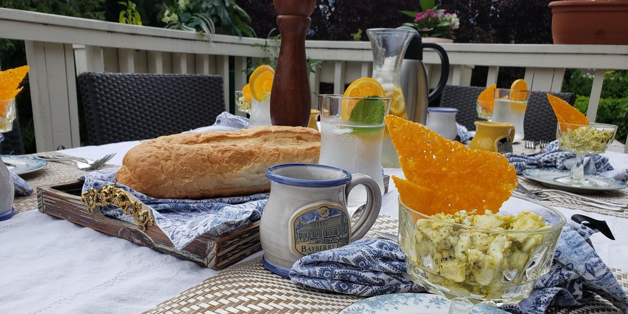 A table set for breakfast with food and drink on an outdoor patio.