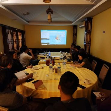People in a meeting watching a projected screen.
