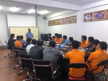 A man giving a presentation to a group of people in a meeting room.