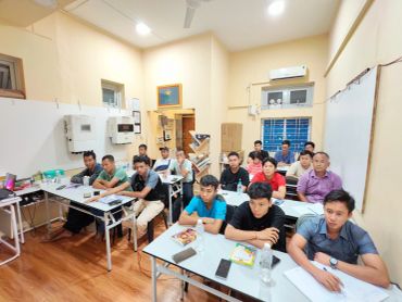 Classroom full of men attending a session.