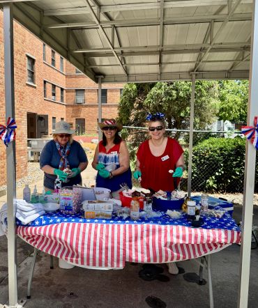 Three women at a festive table with American flag decor.