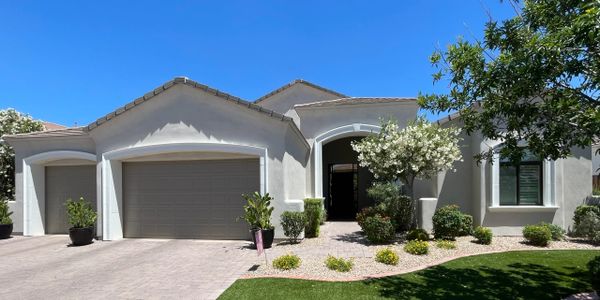 Modern single-story house with a three-car garage and landscaped front yard.