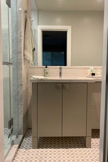 Modern bathroom vanity with sink and mirror in a neutral color scheme.