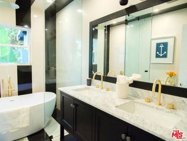 Beautiful carrera marble tile countertops and custom black and white ceiling tile layout. 