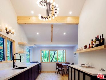 New kitchen layout, faux wood beams and carrera marble countertops with luxurious chandelier.