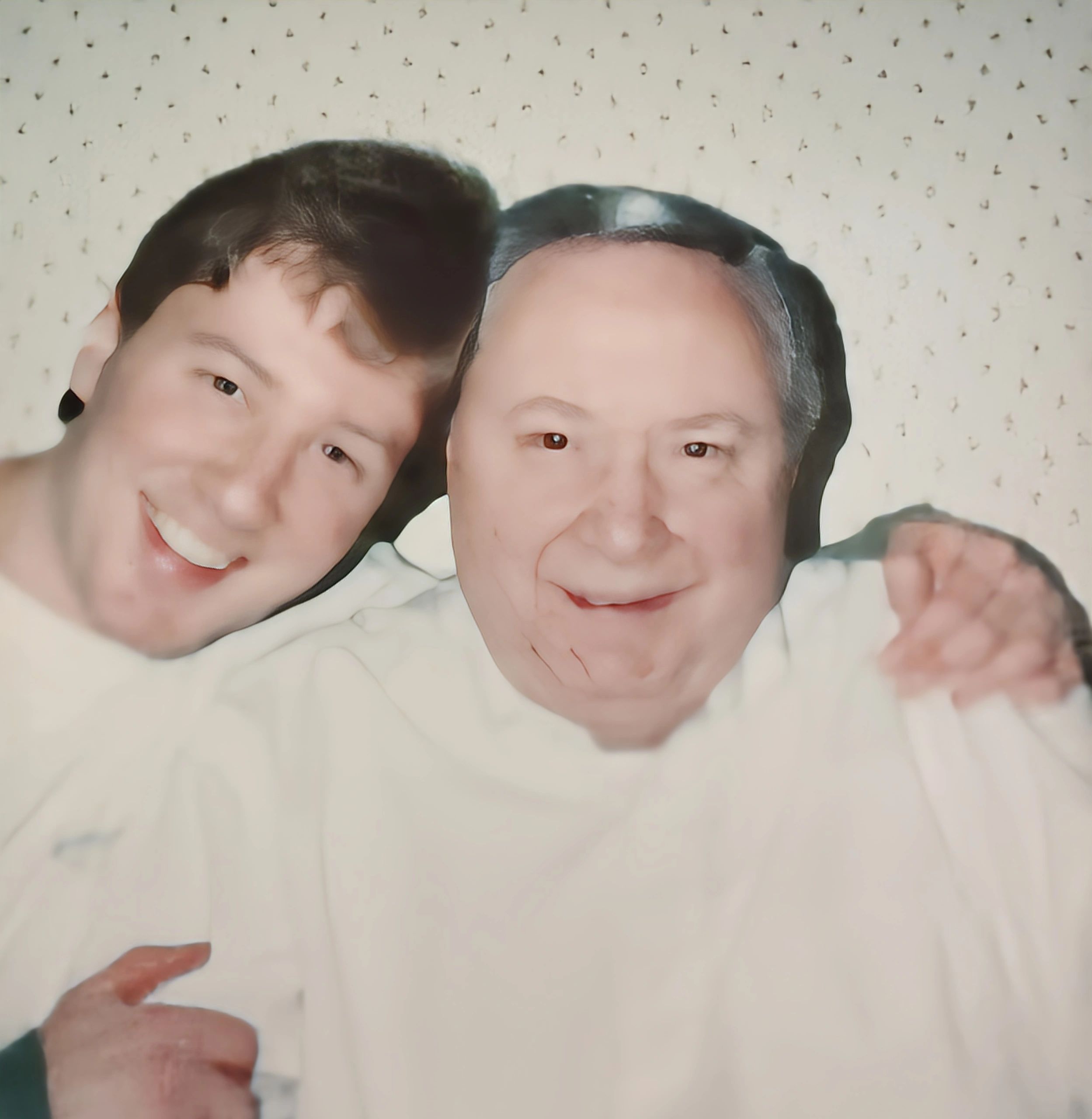 Two men smiling happily with arms around each other.