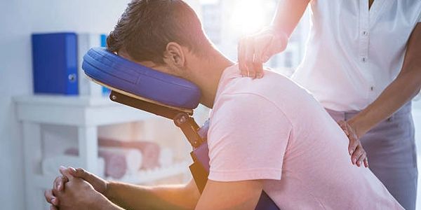 Man receiving a shoulder massage in a therapy setting.