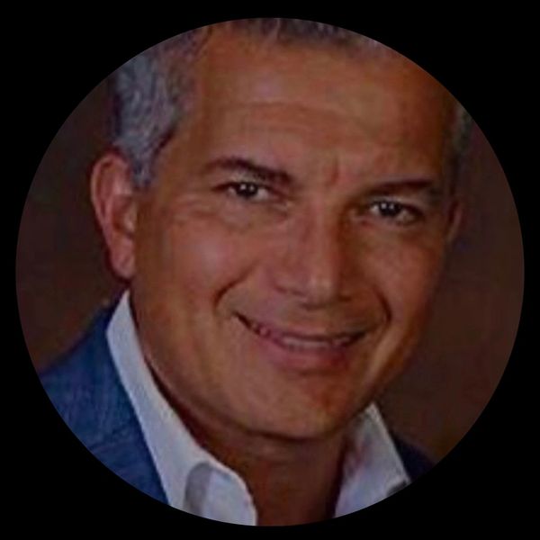Smiling man with gray hair in formal attire.