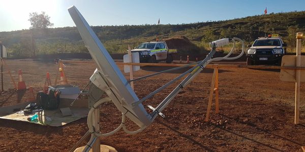 Field site with scientific equipment and vehicles in a rocky landscape.