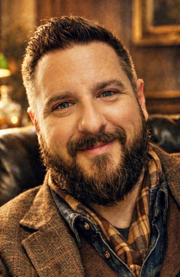 Smiling man with beard and short hair.