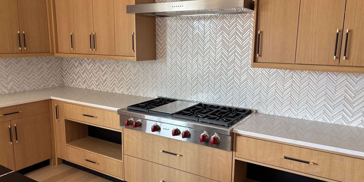 CUSTOM KITCHEN IN LIVINSTON NJ. WOOD COLORED CABINETS WITH BLACK AND WHITE COUNTER TOPS