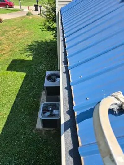 Technician installing gutter guards on a Clarksville home to prevent clogs and improve water flow.