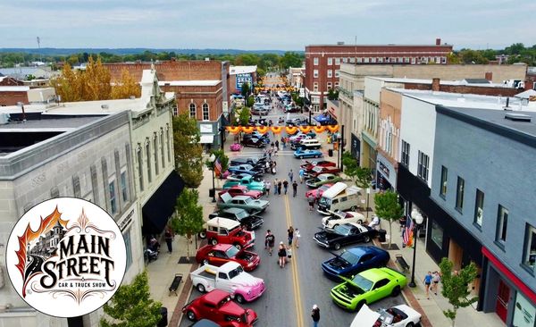 A lively main street car and truck show with vintage vehicles.