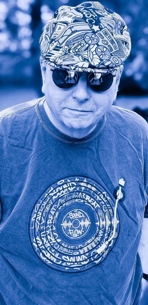 Man wearing a music-themed hat and t-shirt with sunglasses.