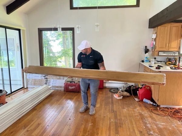 a man moving a large piece of wood in a room
