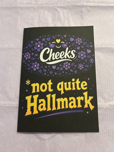 Greeting card with 'Cheeks not quite Hallmark' text and floral design.