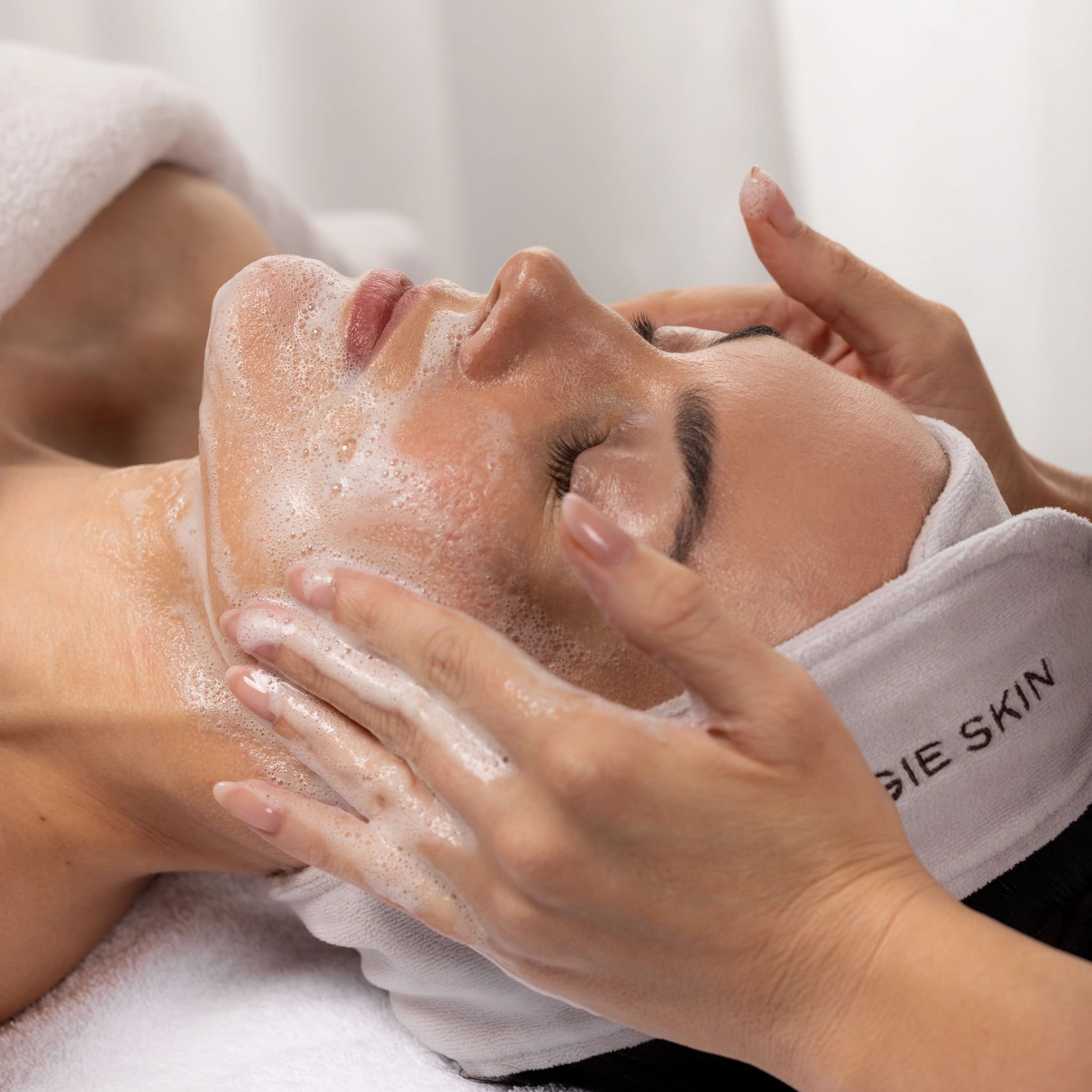 Facial cleansing with foam mask at a spa treatment.