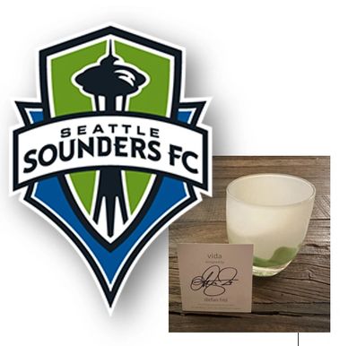 Seattle Sounders FC logo alongside a Vida scented candle and card.