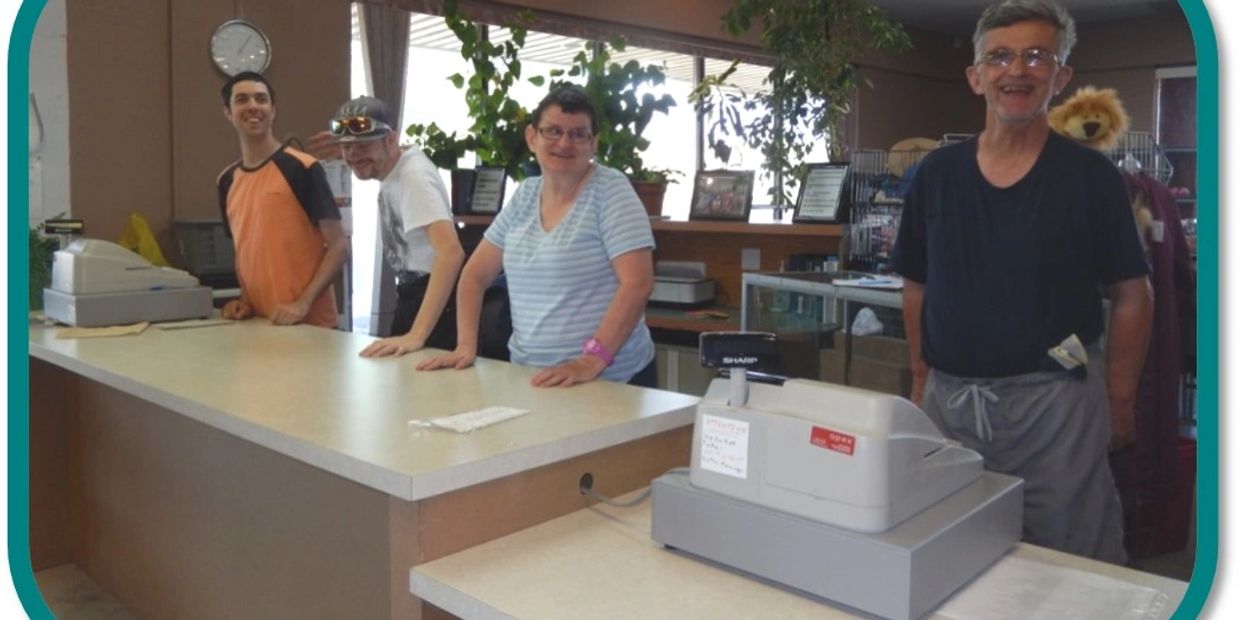 SDS clients are standing behind the counter of the Jarrett Thrift Shoppe.