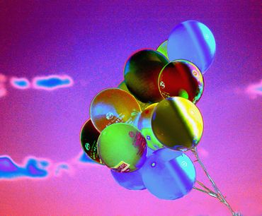 Colorful balloons against a vivid gradient sky.