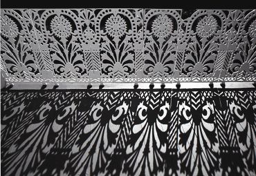 Intricate metal design casting shadows on the floor.
