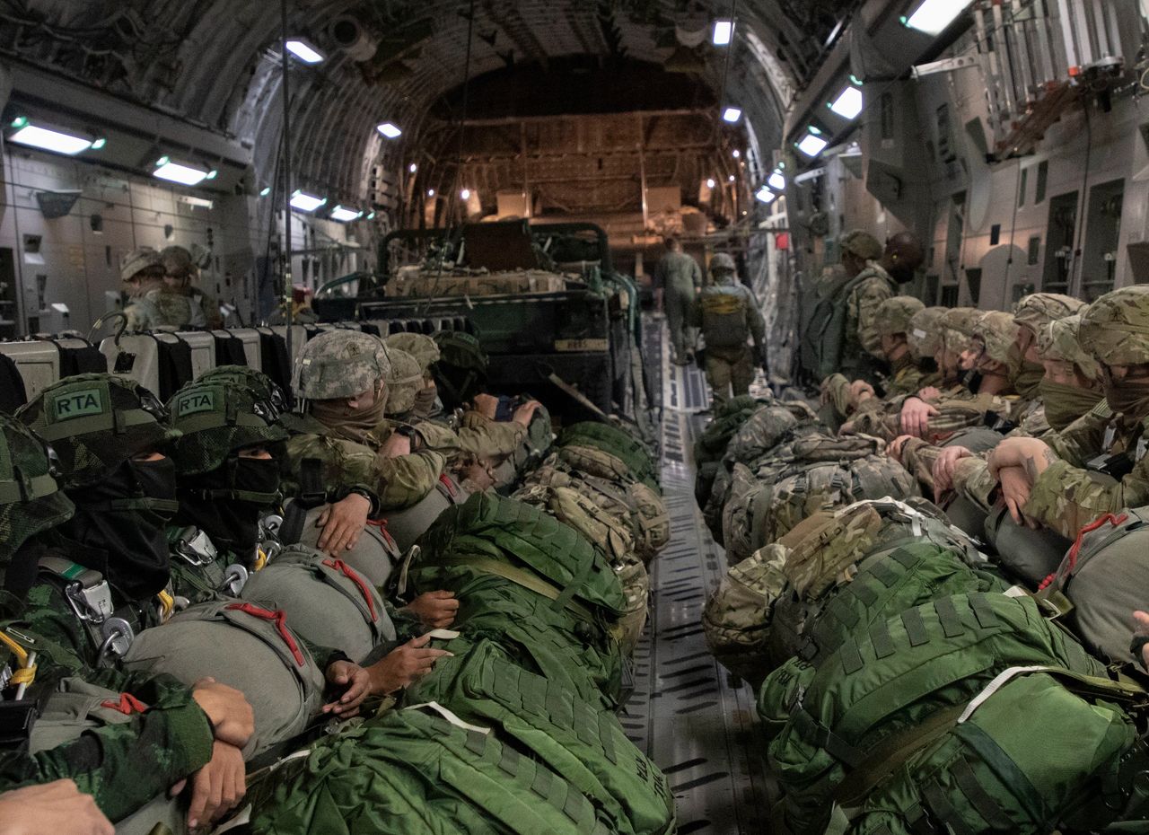 U.S. paratroopers utilizing T-11 parachutes conduct an airborne operation  from a C-130 Hercules aircraft