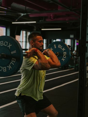 Man lifting a barbell in a gym during a workout.
