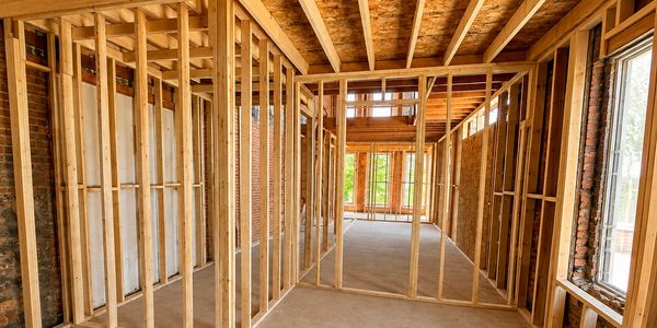 Interior of a house under construction with wooden framing.