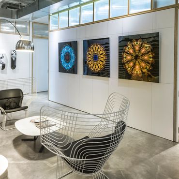 Triptych of large iridescent mandalas on black backgrounds in interior design studio