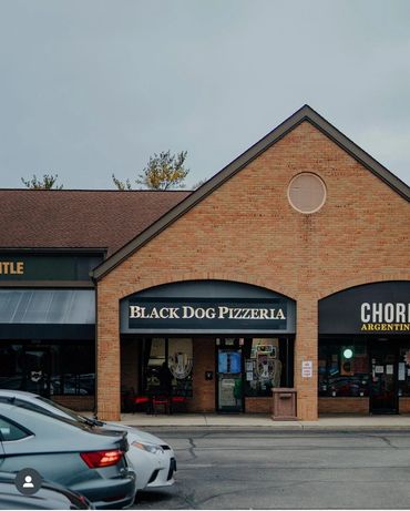 A street view shot of the pizza shop in the strip mall.  