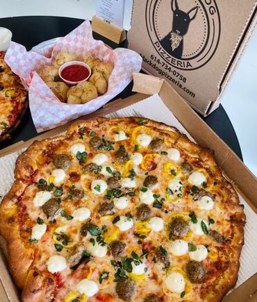 A meatball and cheese pizza, garlic knots, and an upright branded logo box.  
