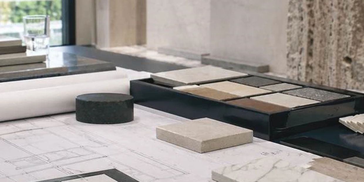 Architectural design workspace with material samples and blueprints.