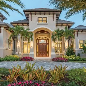 Luxurious modern house entrance with palm trees and garden.