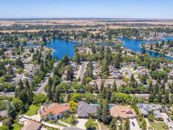 Aerial view of a suburban neighborhood with lakes and trees.