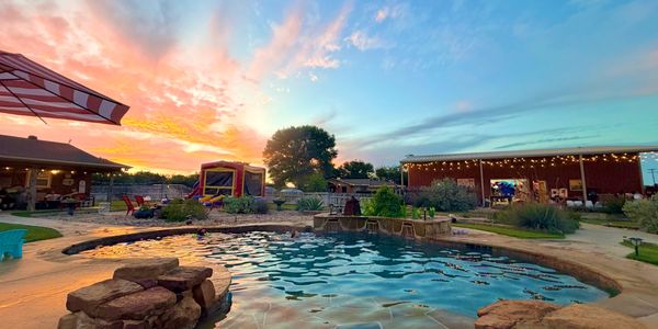 Resort-style courtyard at 3W Venue & Hacienda with pool, patio, outdoor games, and sunset for privat
