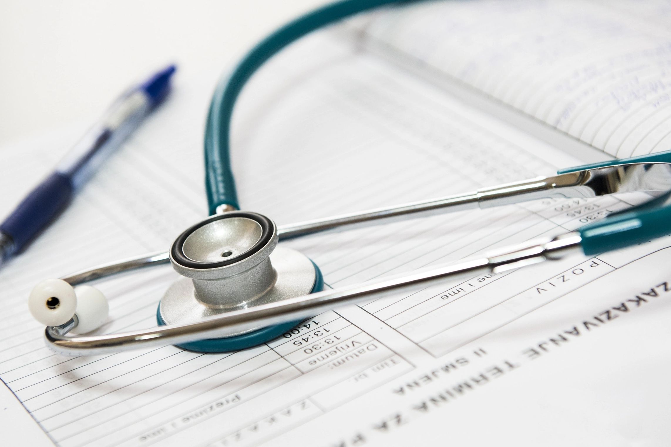 Assessing the client, taking notes.  Picture of paper, teal stethoscope, and pen.