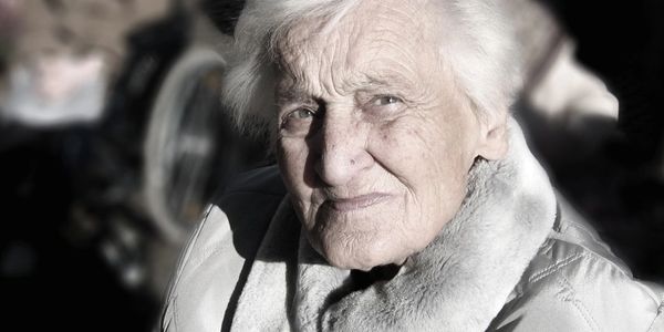 Elderly woman outdoors in grey winter down coat