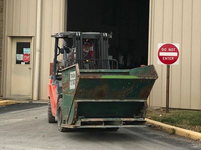 forklift moving dumpster