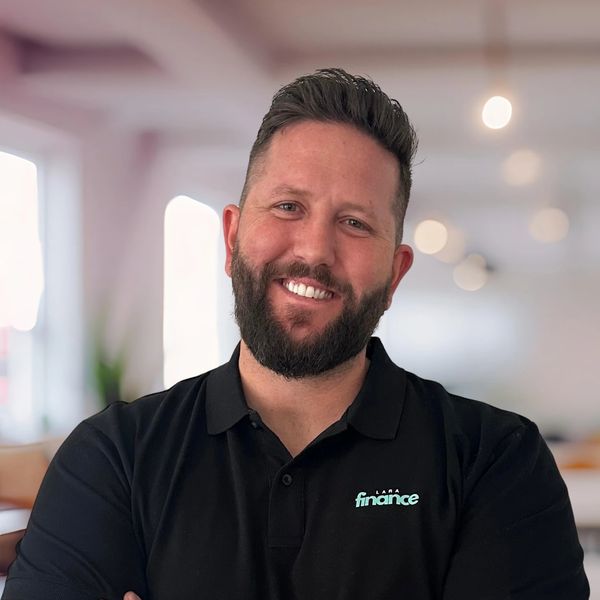 Smiling man with beard in a black shirt.