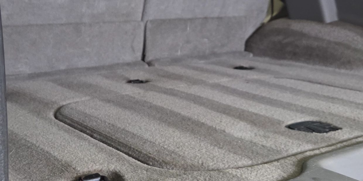 Empty gray car seat with seatbelt slots