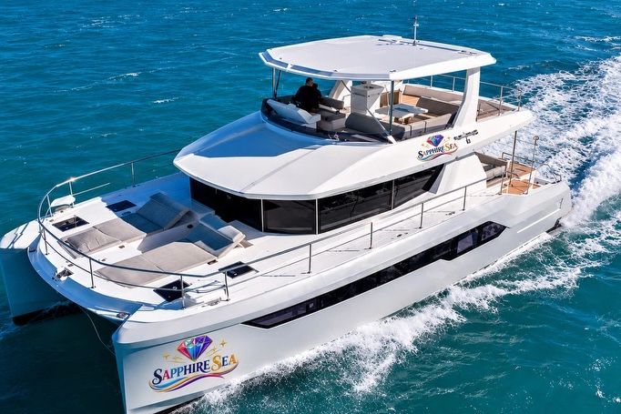 A luxurious white yacht named Sapphire Sea cruising in blue waters.