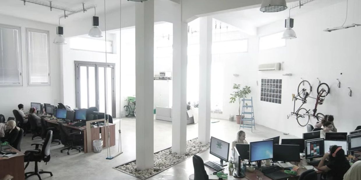 Bright, modern office space with desks, computers, and bicycles mounted on the wall.