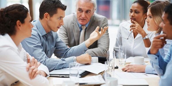 Business team engaged in a serious discussion around a conference table.