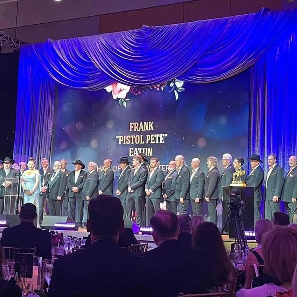 Formal ceremony honoring Frank 'Pistol Pete' Eaton with many attendees on stage.