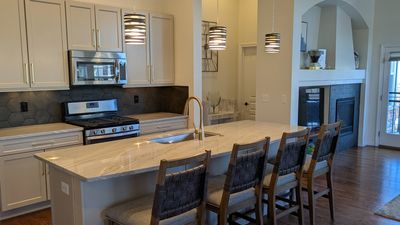 Kitchen renovation with new cabinet doors, painted cabinets, quartzite countertop, and tile