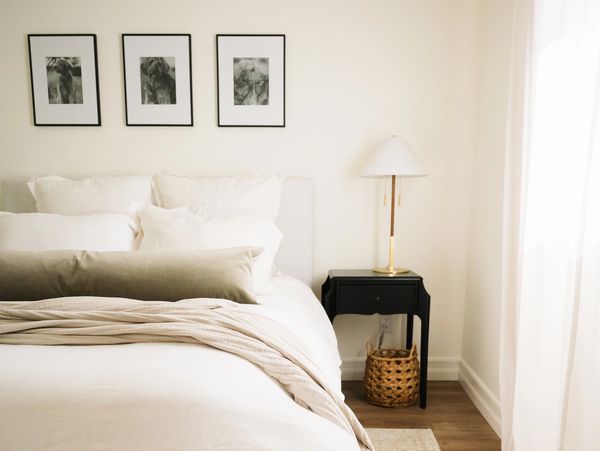 Cozy, neutral-toned bedroom with soft bedding and a black nightstand.