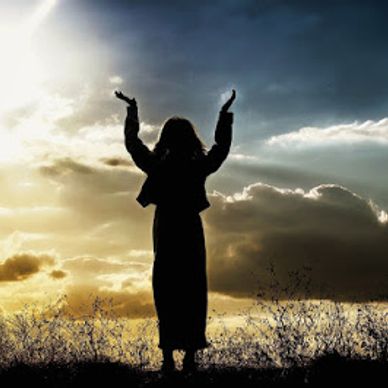 Woman's silhouette standing, lifting her hands to Heaven.