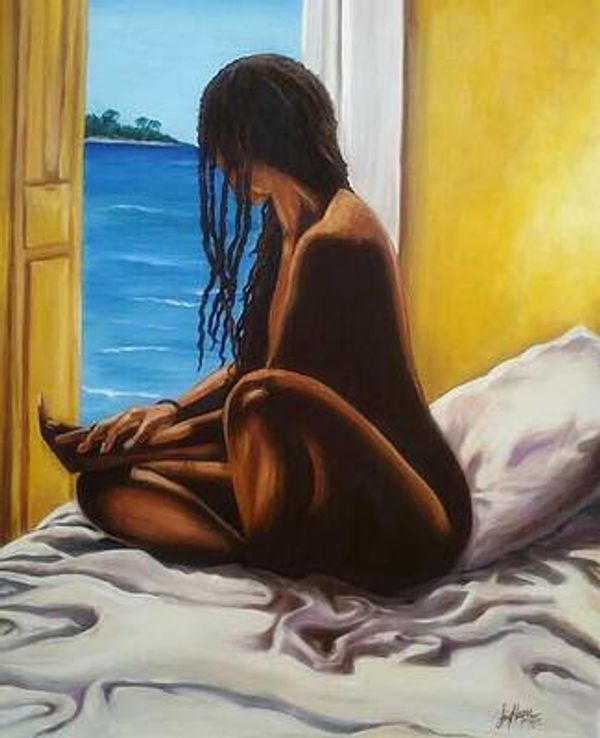 A woman with long hair sitting on a bed by an open window overlooking the ocean.