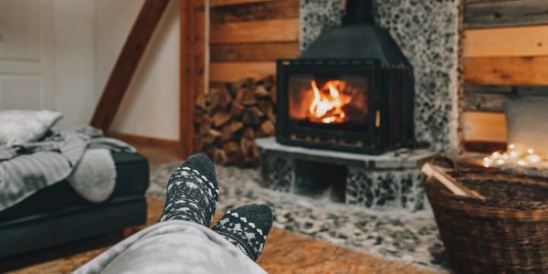 feet sat in front of a log burner fireplace