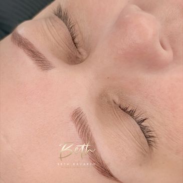 Close-up of freshly microbladed eyebrows on closed eyes.
